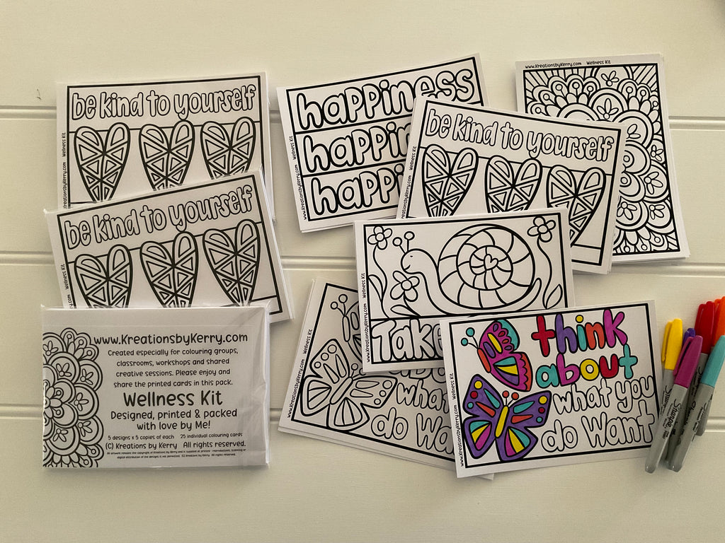 A wellness coloring kit displayed on a light beige wall, featuring multiple black-and-white printable sheets with motivational phrases and mandala/heart designs, a printed package insert, and a few colored markers.