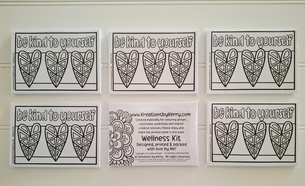 Six printable or physical cards arranged in two rows on a white wall. The top row shows three cards with the phrase 'be kind to yourself' above three outlined heart designs.