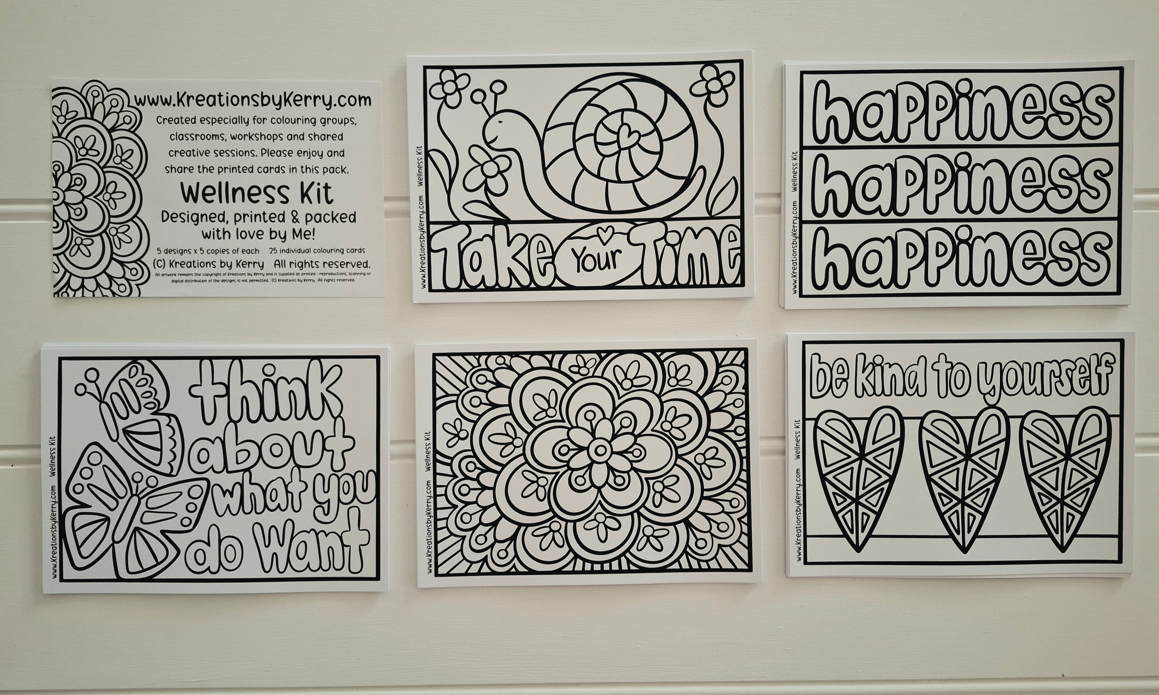 Six black and white printable coloring/meditation cards arranged in a 2x3 grid on a white wall. The cards feature phrases like 'happiness happiness happiness,' 'take your time,' 'think about what you do want,' and 'be kind to yourself,' along with floral and bird line-art designs.