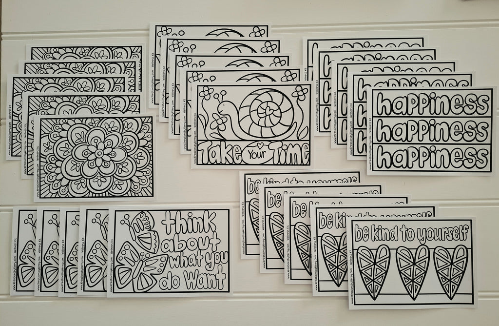 A set of black and white printable cards or stickers with motivational quotes and doodle designs, arranged in overlapping rows on a white surface. Visible text includes phrases like 'happiness happiness happiness,' 'think about what you do want,' 'be kind to yourself,' and 'take your time.