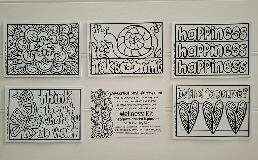 Six black-and-white printable coloring/meditation sheet designs arranged on a white wall, including floral mandala art, a snail with the word 'happiness,' motivational phrases like 'happiness happiness happiness,' a butterfly with 'Think about what you do want,' a center text panel reading 'Wellness Kit' with the website Kretationsbykerry.com, and two heart designs with 'be kind to yourself.
